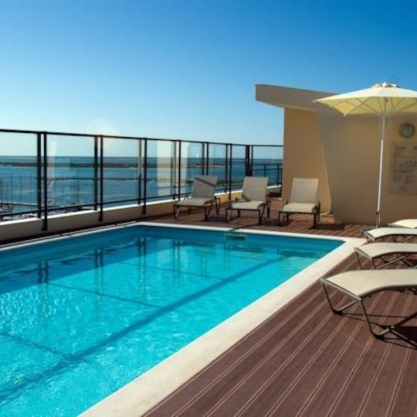 View of the roof terrace of Marina Gigi with swimming pool and sun loungers. Holiday rental in Olhão in the south of Portugal
