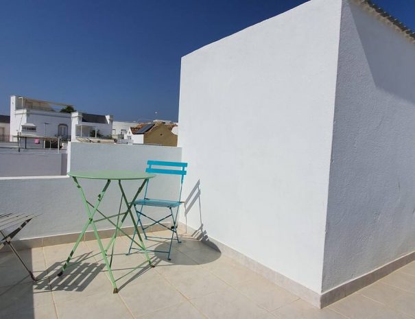 Toit terrasse ave table de petit déjeuner et vue sur les toits d'Olhão de Casa Gigi, Location de vacances à Olhão dans le sud du Portugal